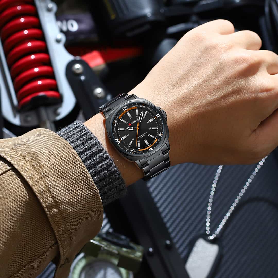 Moška ročna ura Curren Zenith Black na zapestju v kombinaciji s športno jakno.