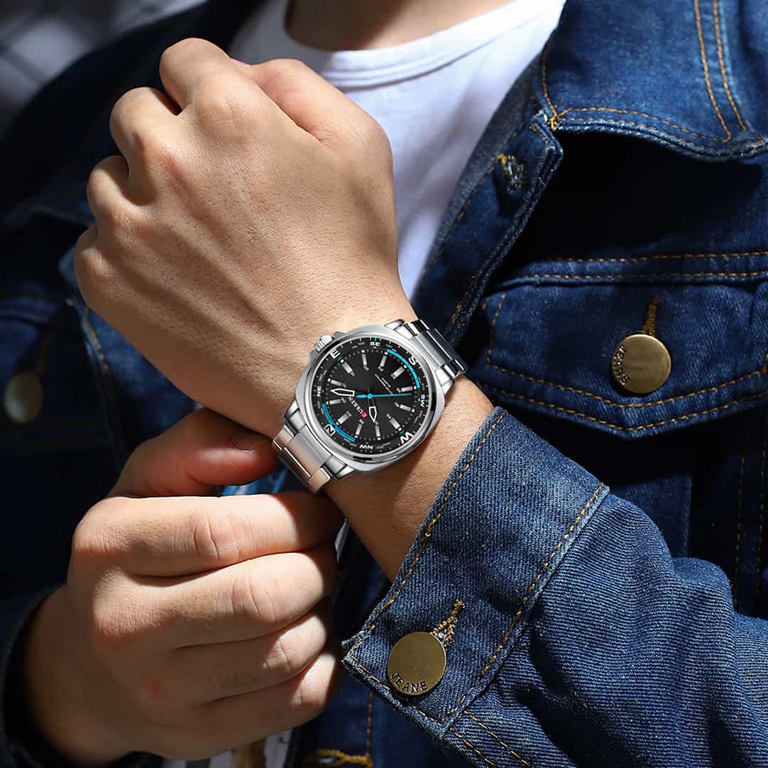 Moška ročna ura Curren Zenith Silver/Black na zapestju ob denim jakni.