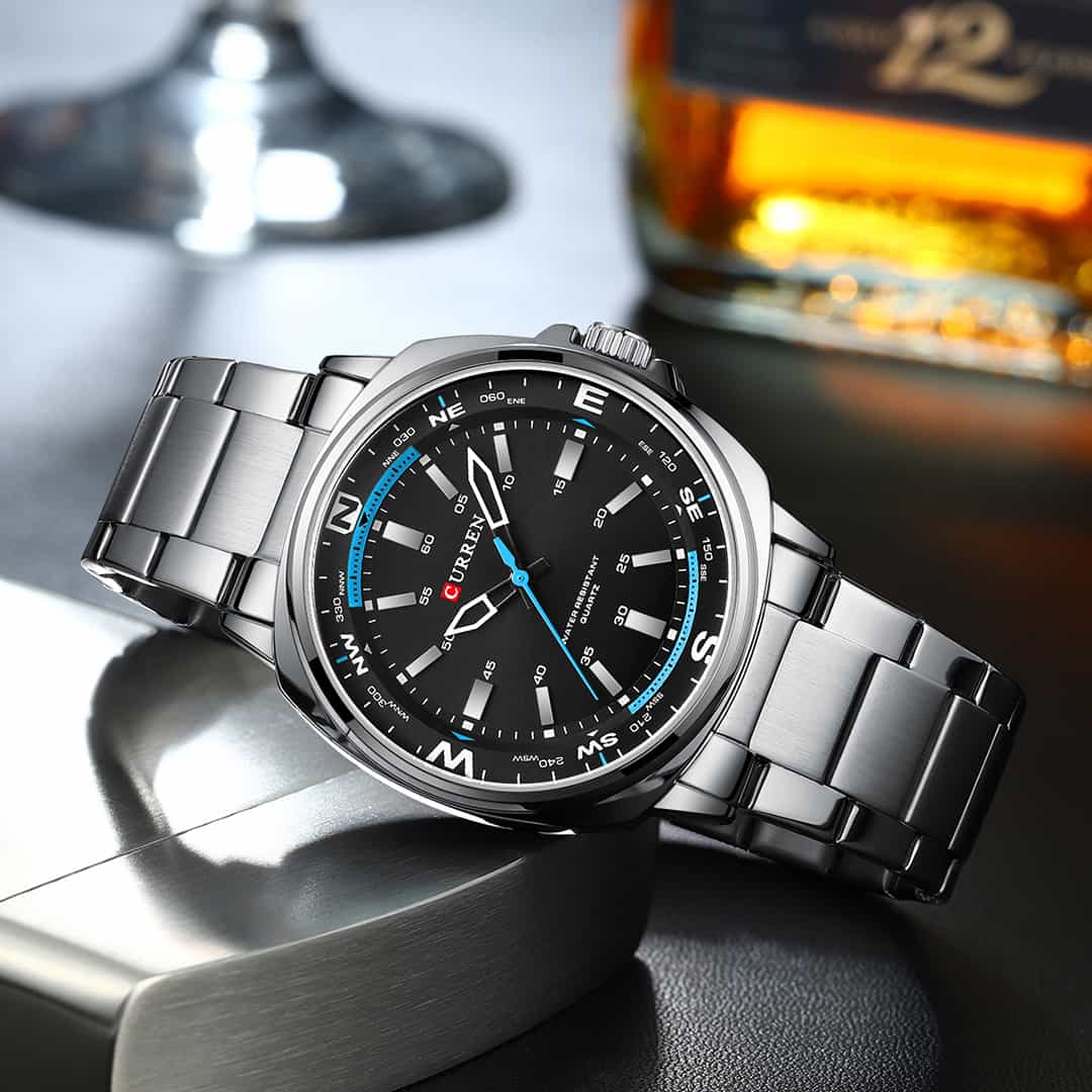 Moška ročna ura Curren Zenith Silver/Black v elegantnem okolju ob steklenici.