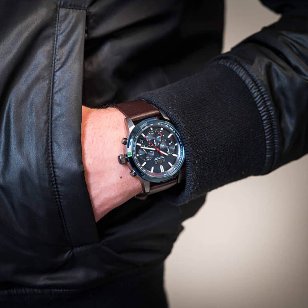 Moška ura Hugo Boss Solgrade 1514030 na zapestju z usnjenim rjavim paščkom in športno modro številčnico